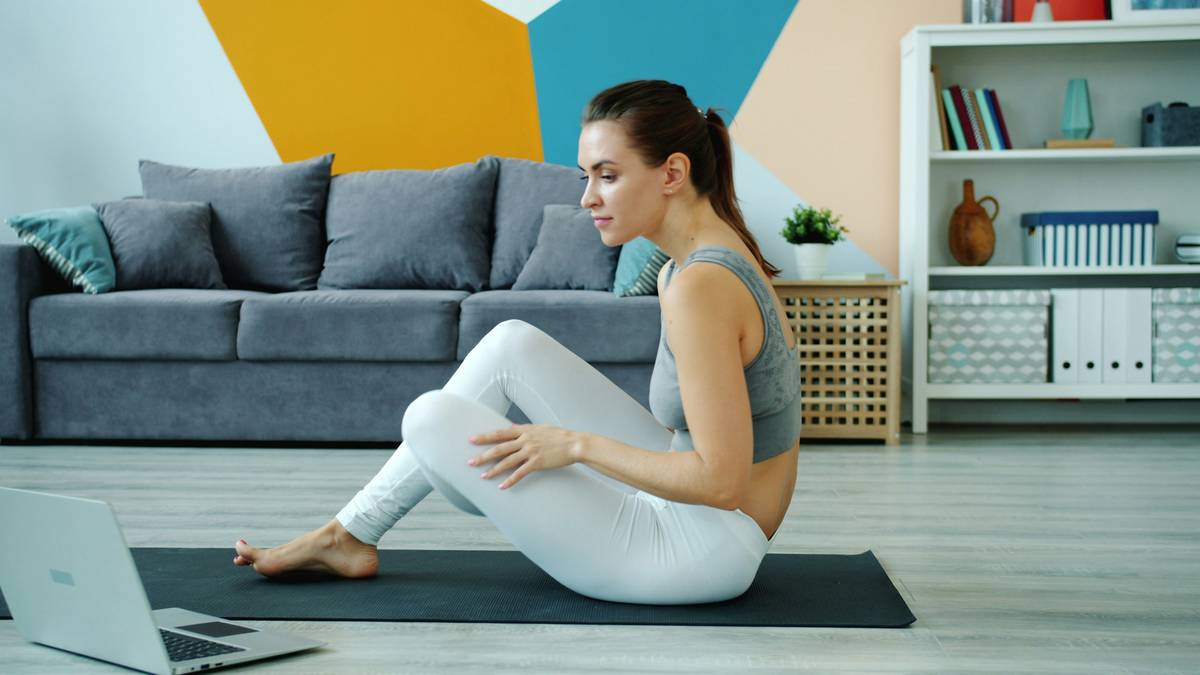 chatgpt prompt for workout plan showing a person reviewing a printed workout routine next to a laptop displaying ChatGPT interface